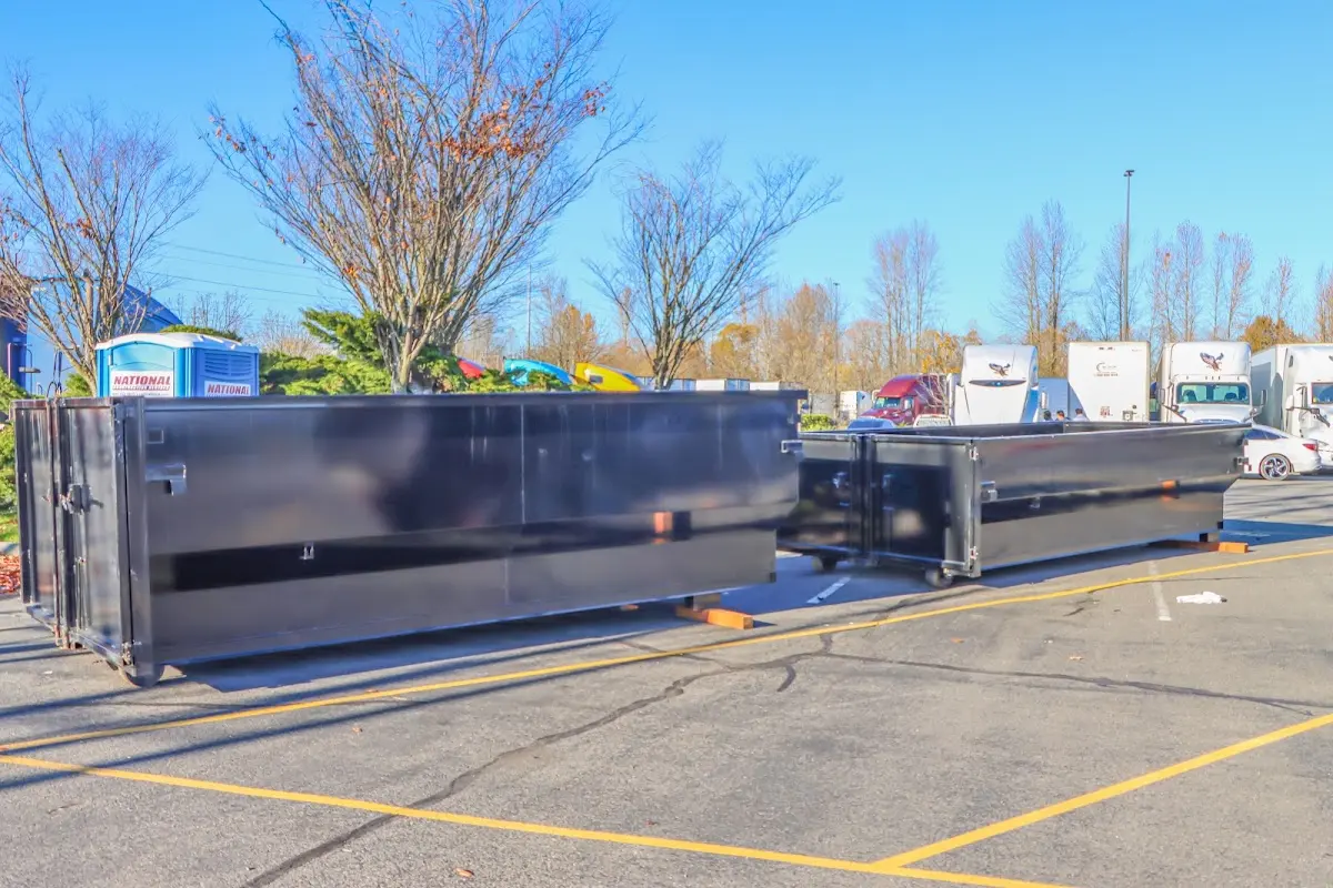 Professional dumpster rental service with roll-off container on residential driveway in Mobile